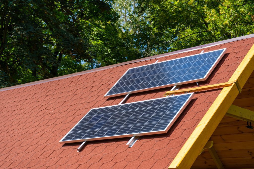 Solar panel on the roof of the house. Red tiles.